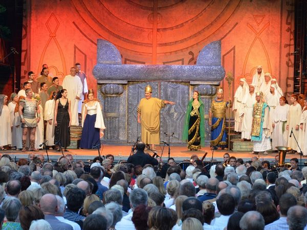 Schauspieler führen das Stück Nabucco auf der Freilichtbühne auf. Das Publikum lauscht gespannt