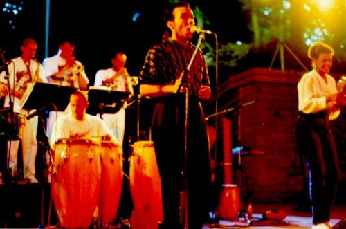 Ein Sänger steht vor einem Chor und singt bei der Karibischen Nacht 1993