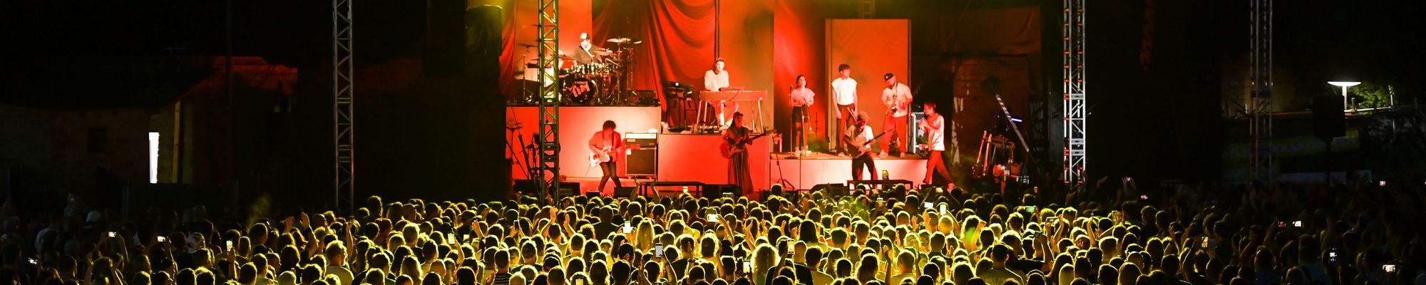 Clueso bei seinem Auftritt 2024 auf der Freilichtbühne mit Band auf der Bühne und Zuschauern davor