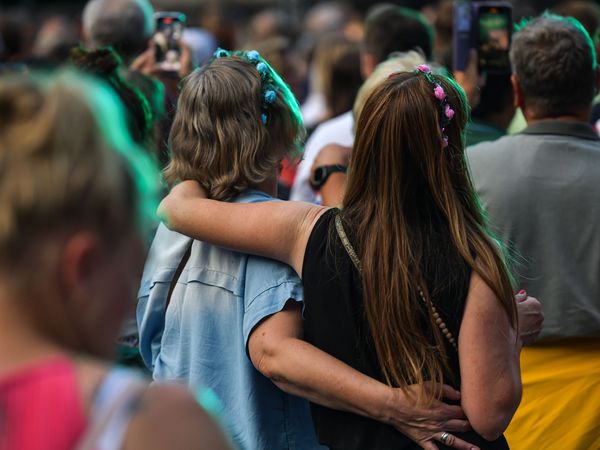 Zwei Frauen halten sich glücklich Arm in Arm.