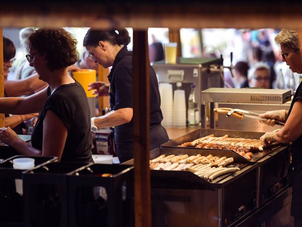 In einer Holzhütte auf der Freilichtbühne wird von einem Team Essen zubereitet