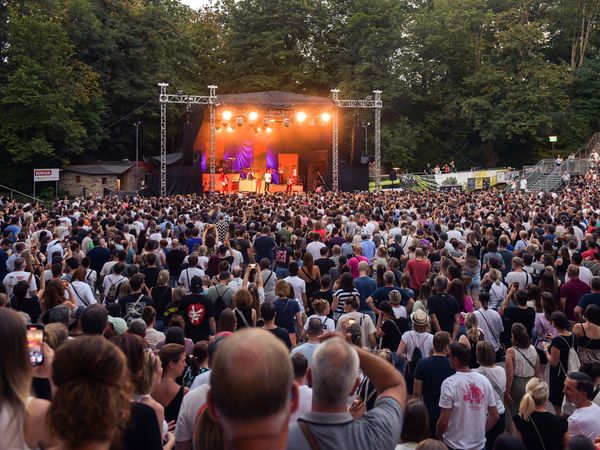 Unzählige Menschen steht im Innenraum der Freilichtbühne - ganz vorne performt ein Künstler auf der Bühne