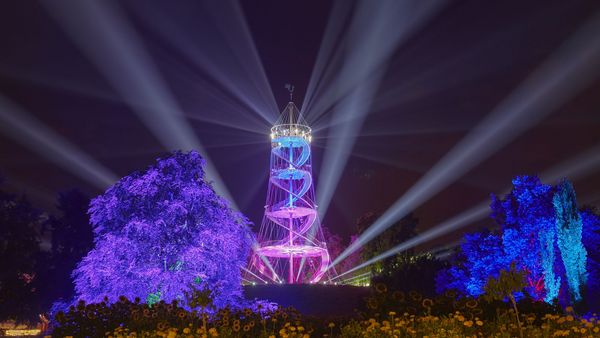 Killesberg-Turm im Dunklen beleuchtet in Lila und Blau mit Strahlern, die in die Nacht leuchten