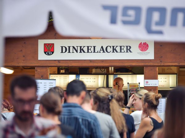 Eine Menschenschlange vor einem Dinkelacker-Stand an der Freilichtbühne