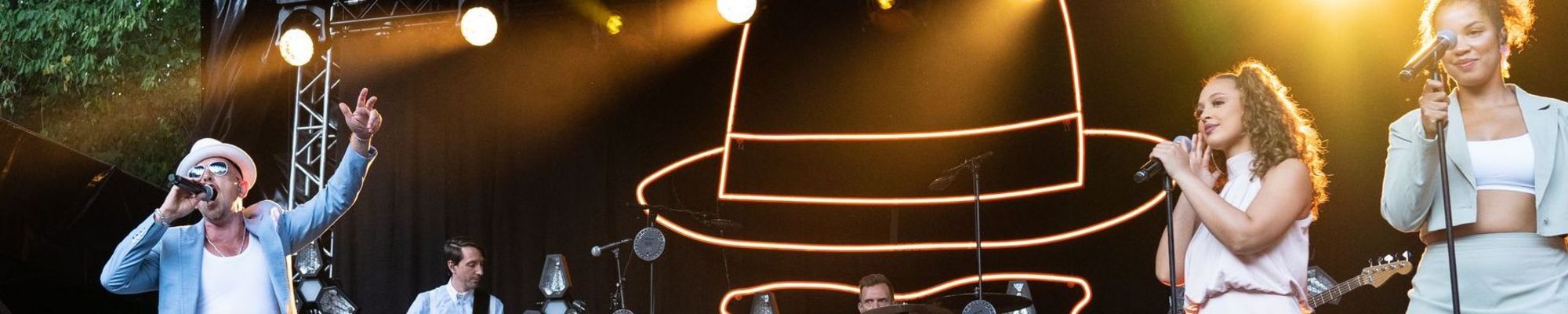 Jan Delay vor seinem Bühnenbild mit Backgroundsängerinnen